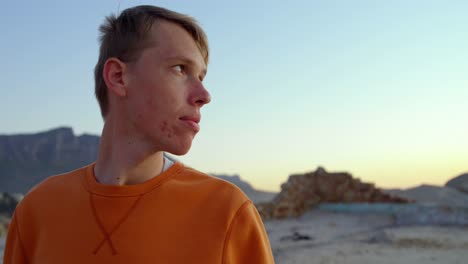 young thoughtful man sitting on beach 4k