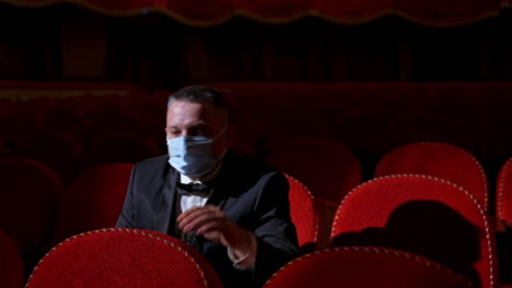 actor in medical mask on theatre. empty classic theater.