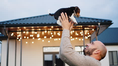 A-young-man-plays-with-a-puppy-in-front-of-his-house.-Sweet-home