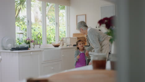 abuela feliz bailando con una niña en la cocina abuela divirtiéndose bailando con su nieta celebrando el fin de semana en casa