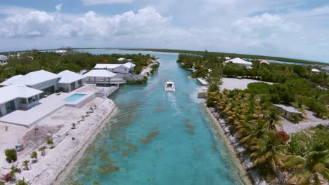 Slow-motion-aerial-shot-of-a-luxury-Yacht-in-a-narrow-valley-with-resorts-and-hotels-surrounding-it