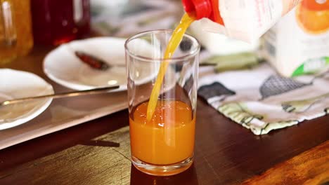 orange juice being poured into a glass