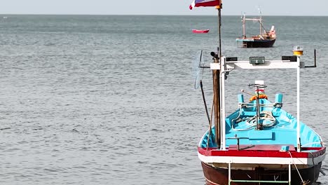 a vibrant fishing boat with a thai flag anchored peacefully in serene ocean waters.