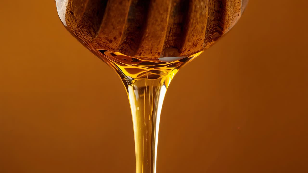 Miele d'oro che gocciola da un cucciolo