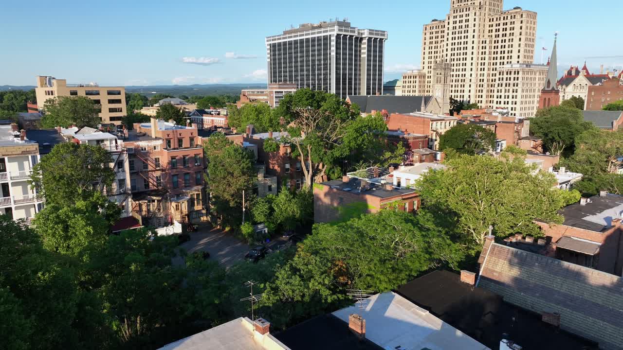 Housing area with home and green planted wall at sunset. Aerial tilt up wide shot. Famous downtown of Albany with state office building. New York, USA