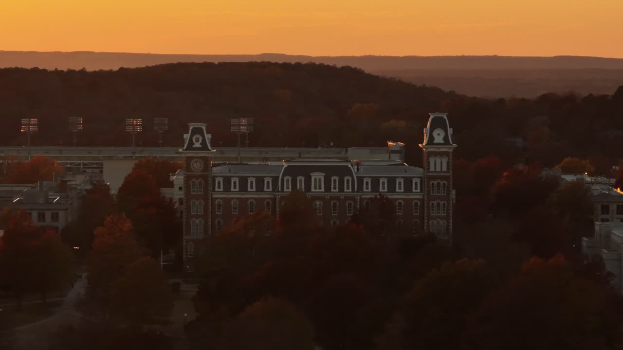 fachada del antiguo edificio principal en el campus de la universidad de arkansas al anochecer