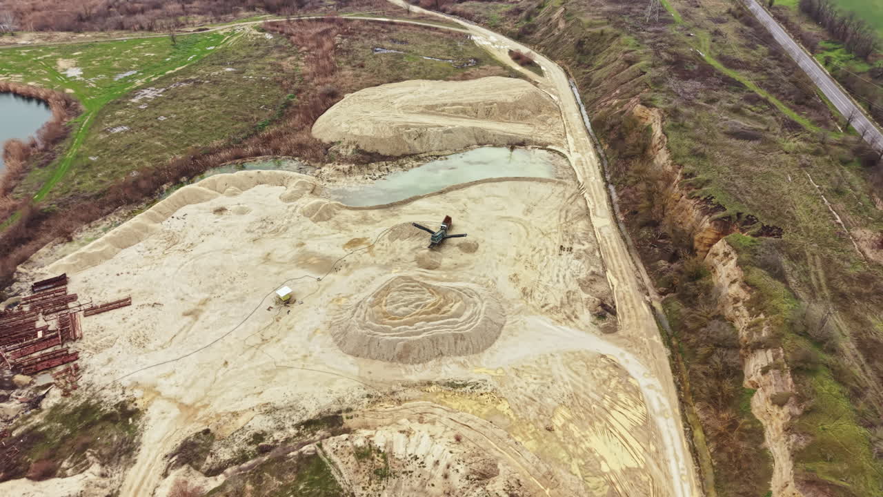 Construction site showing earth moving and shaping at a land development project near a water body in a rural area during daylight hours
