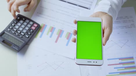 joven usa un teléfono inteligente con pantalla verde