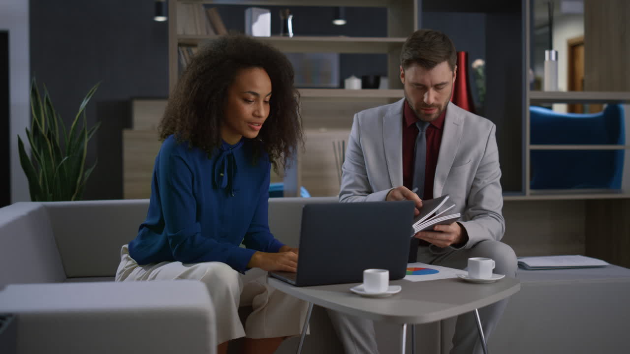 Diverse coworkers couple working laptop call video chat meeting in home office.