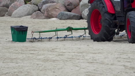 Slow-Motion-Red-Tractor-Beach-Scraping:-Wheel-and-Scraper-View