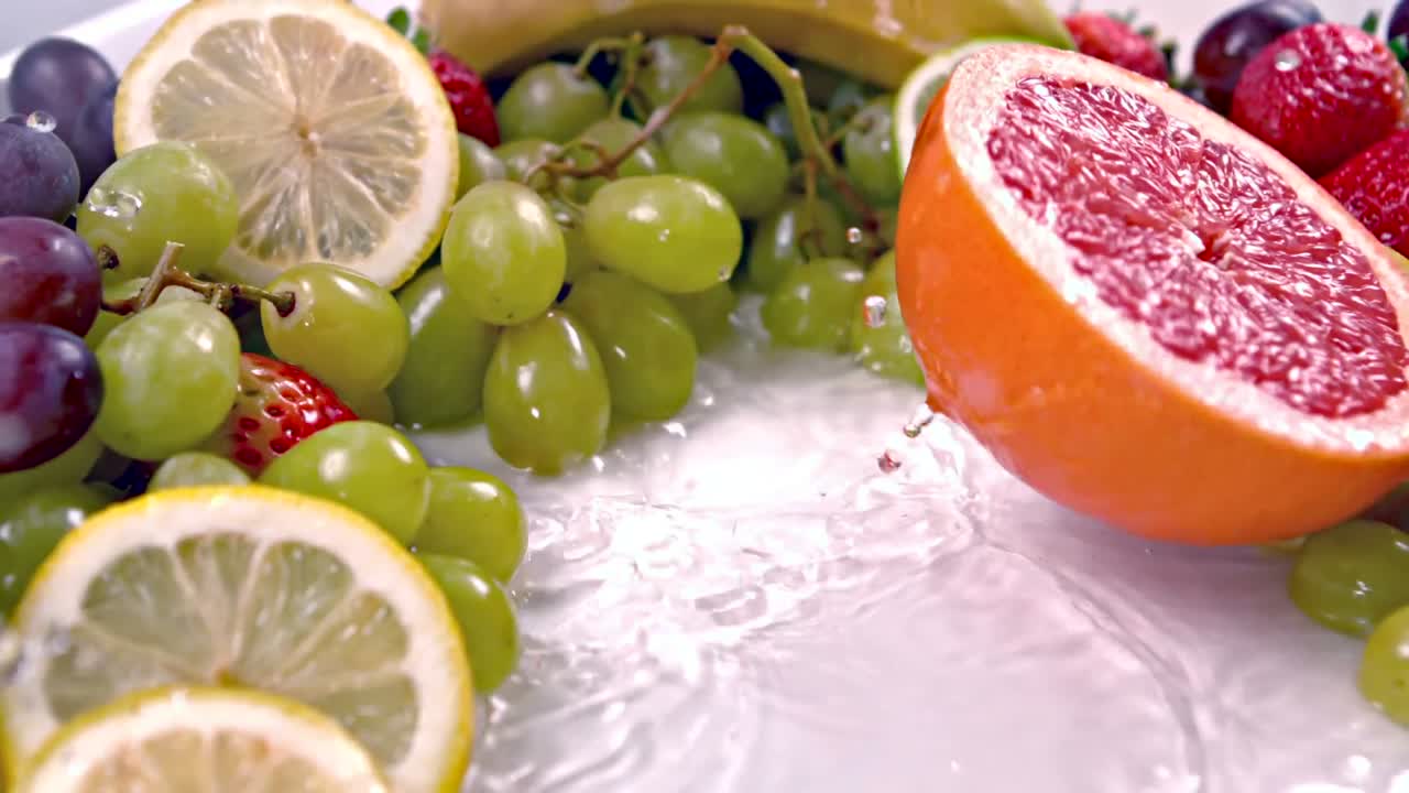 Una metà di pompelmo che cade nell'acqua