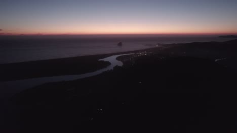 Fireworks-over-coastal-beach-town-at-sunset