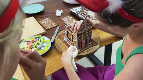 children decorating a gingerbread house