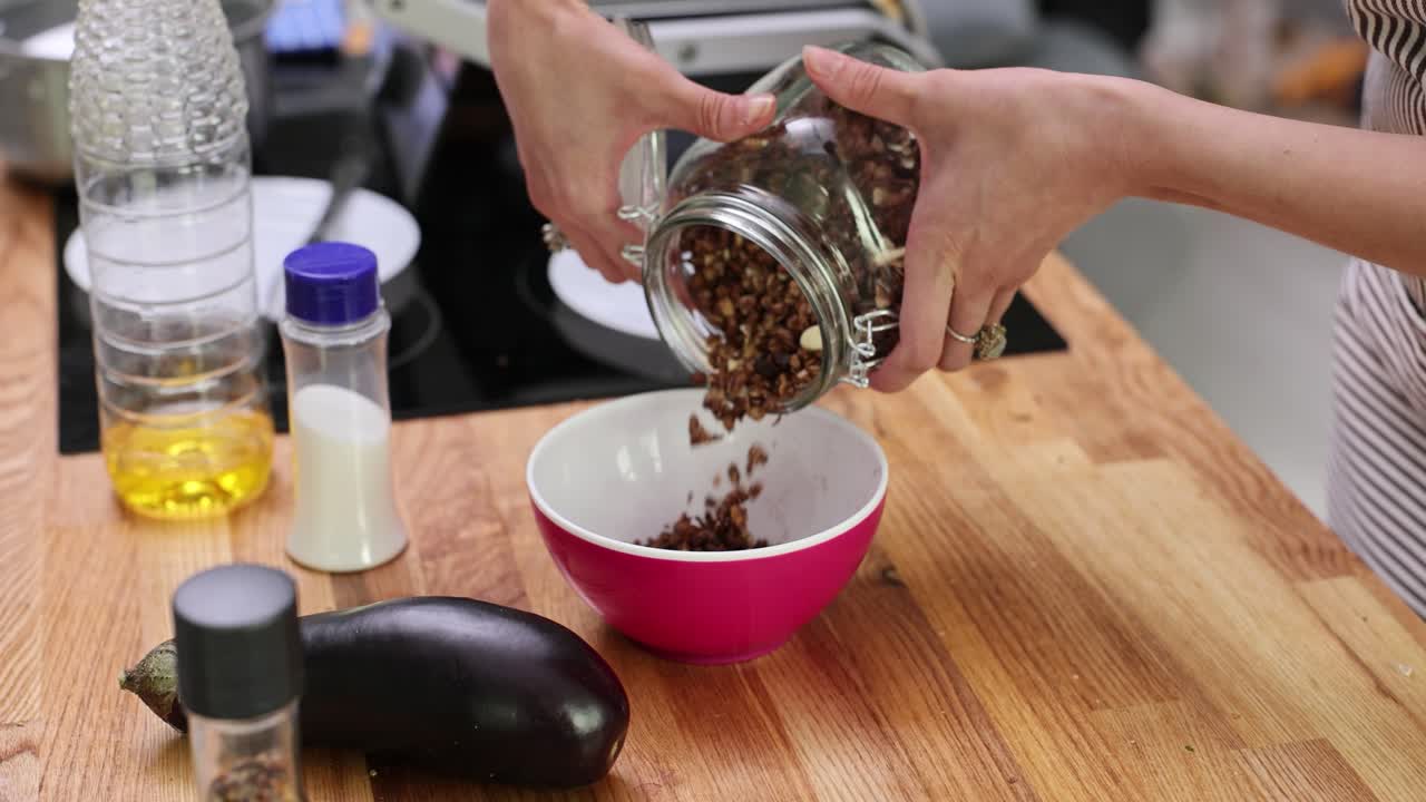 Pouring Granola into a Bowl for Breakfast