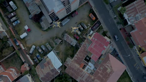 Top-down-aerial-view-following-a-cable-car-gondola-as-it-travels-across-La-Paz,-Bolivia