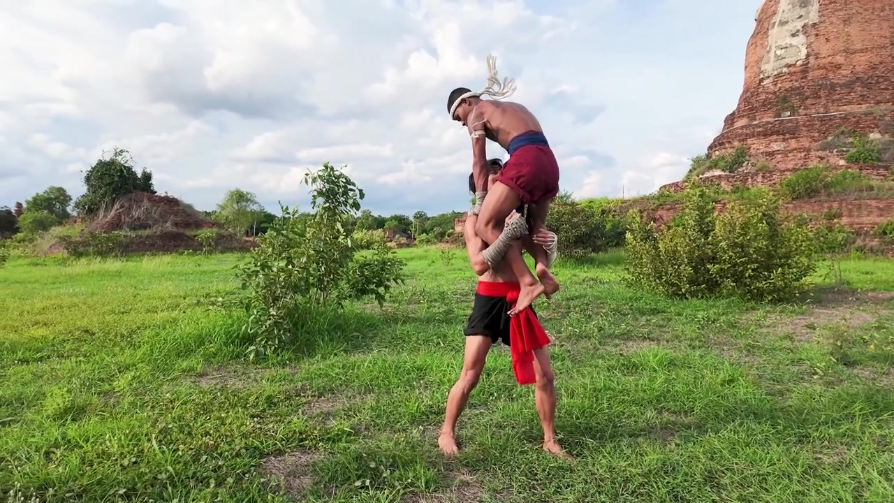 Lottatori di Muay Thai che praticano arti marziali tradizionali vicino a rovine antiche