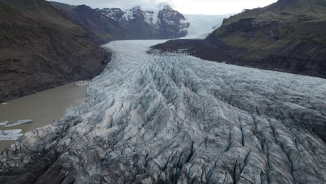 gran glaciar que fluye por un estrecho valle de montaña en islandia