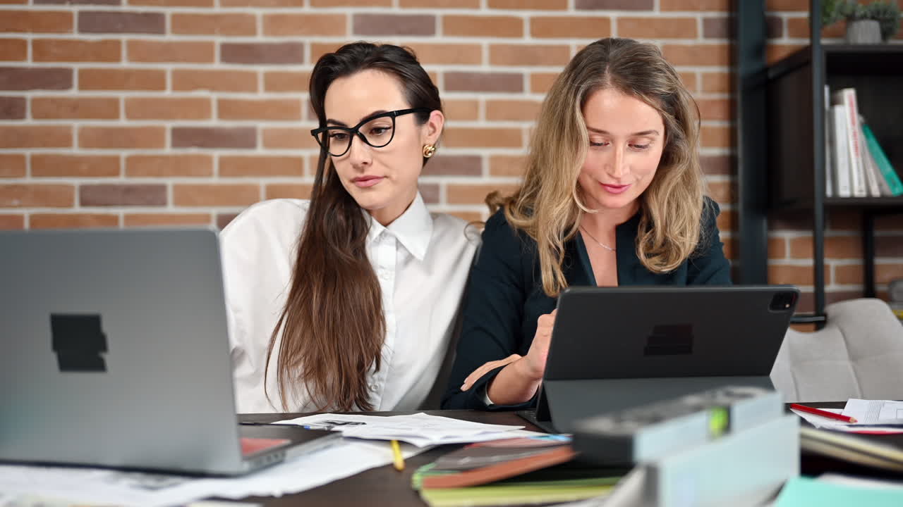 Coworkers analysing building plans and colours in an office