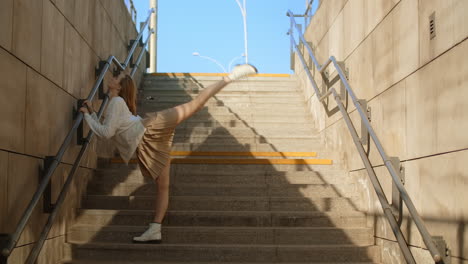young woman stretching on city stairs