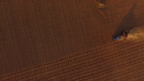 Sowing-fields-with-tractor-and-seeder-in-dusty-field-aerial-view