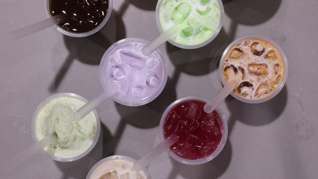 평평한 테이블 표면에서 차가운 주스를 따는 남성 손