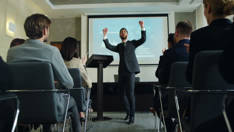 caucasian male business speaker finishing his conference in a meeting and going away cheerfully while people clapping