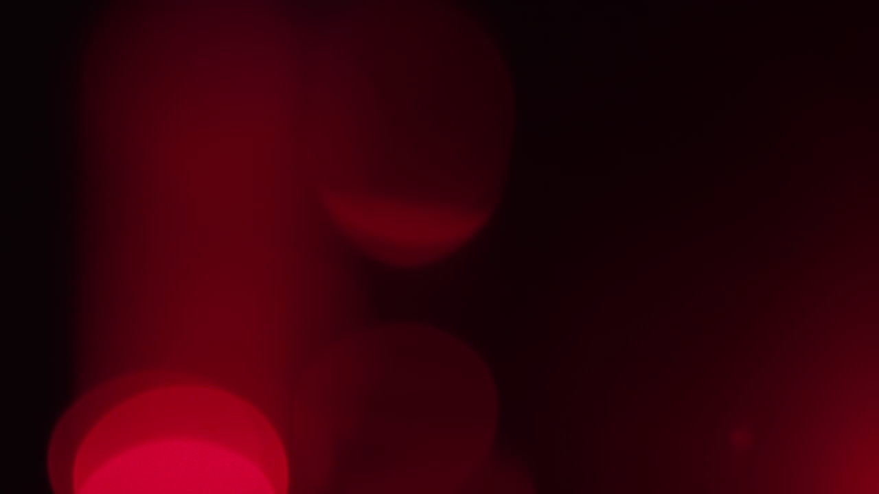 Abstract analogue footage featuring red bokeh drifting slowly in soft focus. Warm crimson hues and handmade texture make it perfect for overlays, installations, or dreamy visual designs.