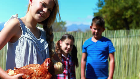portrait of girl carrying a hen in the farm 4k