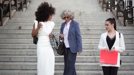 three professional women descending city stairs
