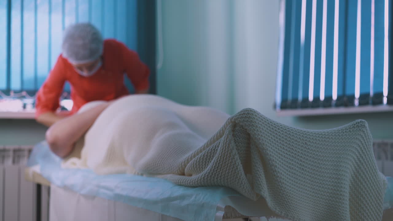 la esteticista trabaja con una mujer joven y grande. la cara se centra en las piernas.