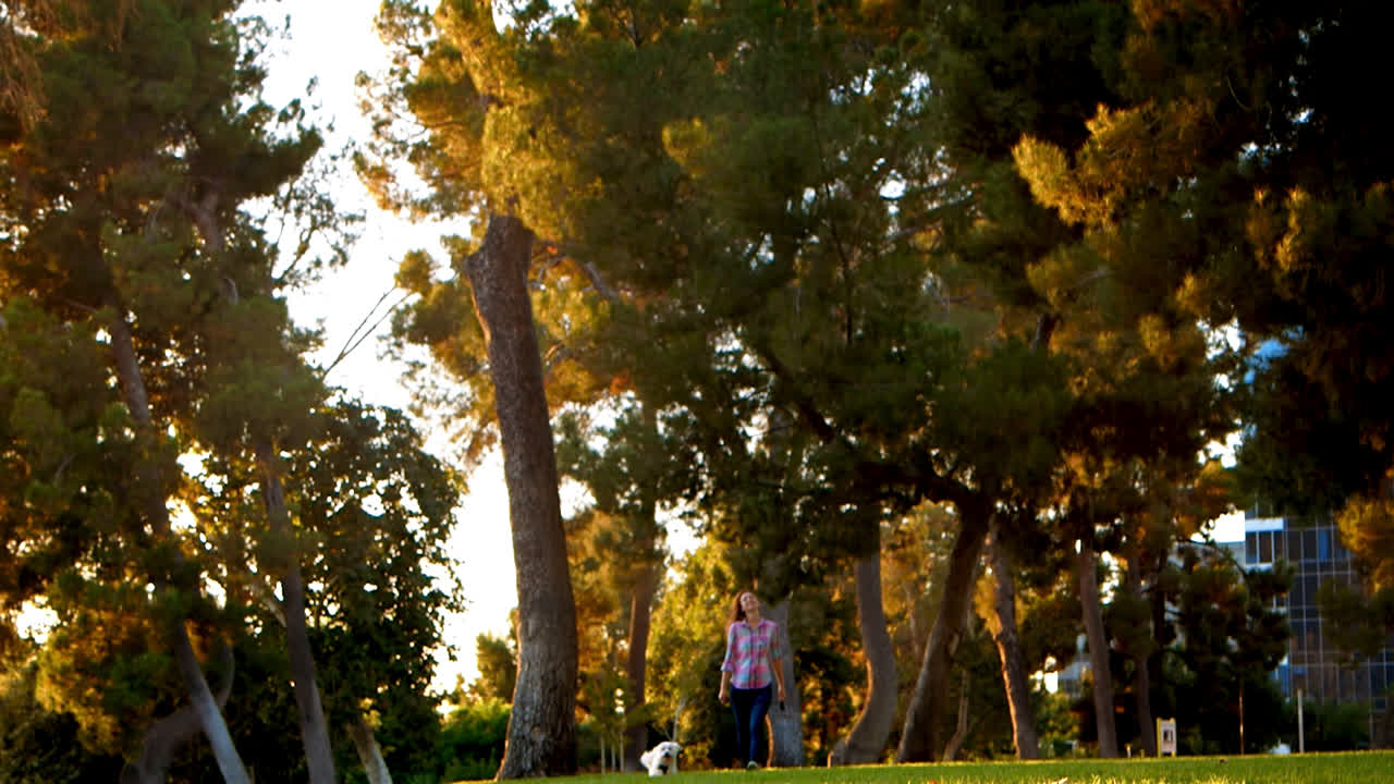 젊은 여성이 카메라를 향해 행복한  ⁇  개를  ⁇ 고 있습니다.