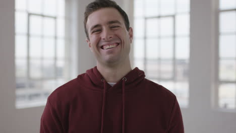 close up portrait of handsome young caucasian man laughing cheerful enjoying new apartment lifestyle change