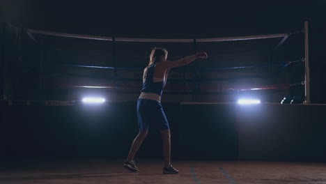 Beautiful-female-boxer-conducts-a-fight-with-shadow-while-exercising-in-the-gym.-Slow-motion.-steadicam-shot