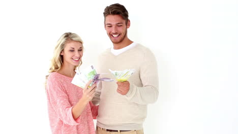 una pareja joven y atractiva mostrando su dinero.