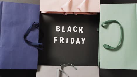 Texto-De-Viernes-Negro-En-Blanco-Sobre-Negro-Con-Bolsas-De-Regalo-De-Colores