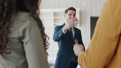 real estate agent showing house to clients