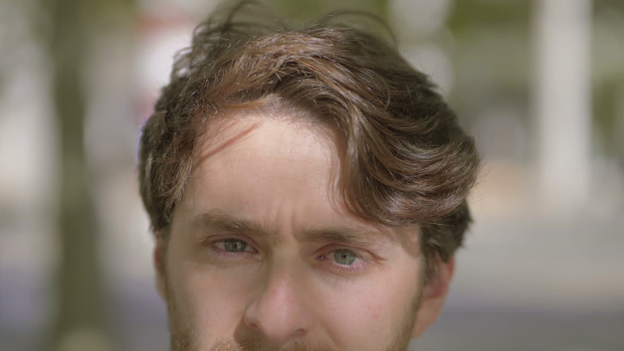 멋진 남자가 야외에서 카메라를 보고 있습니다.