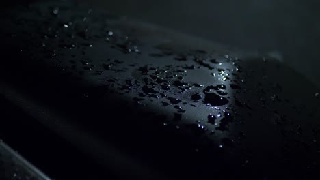 raindrops on the seat of a motorcycle. dark night.