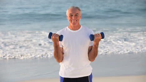 hombre de edad avanzada trabajando sus músculos con pesas