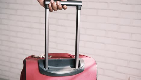 person carrying a red suitcase