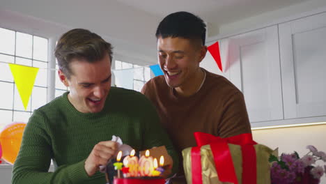 Same-Sex-Male-Couple-Celebrating-30th-Birthday-At-Home-With--Man-Receiving-Gift-From-Partner