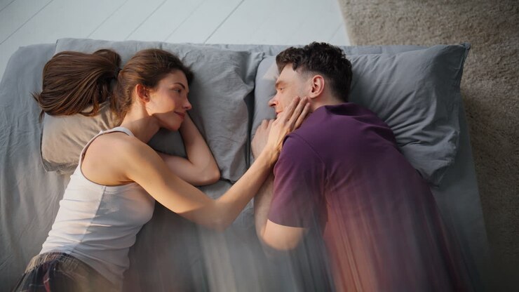 Enamoured couple awaking together lying mattress closeup. Braid touching groom