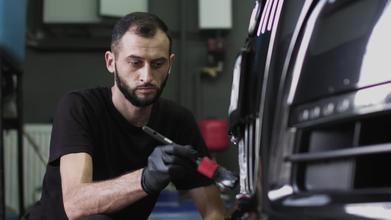 Man detailing a car in a repair shop