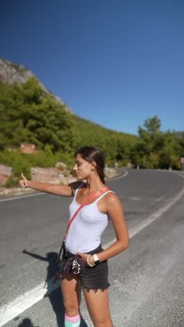 woman hitchhiking on a mountain road