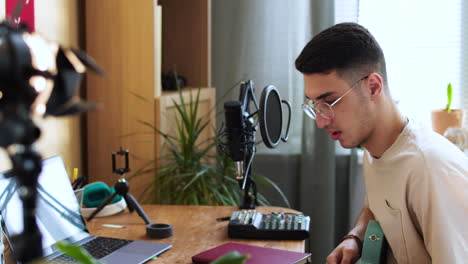 young man playing music at home