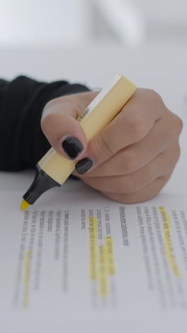 close-up of hand highlighting text on a document