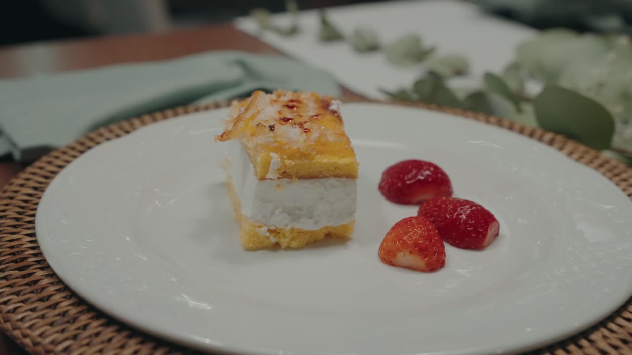 Close-up of layered sponge cake with cream and fresh strawberries served on a plate