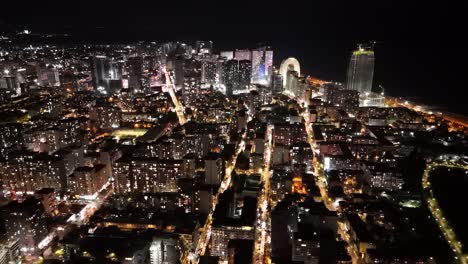 cinematic nighttime drone footage of batumi skyline and illuminated skyscrapers.