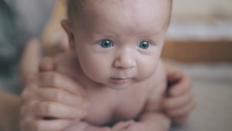 infant-boy-with-blue-eyes-and-blond-hair-lies-on-stomach
