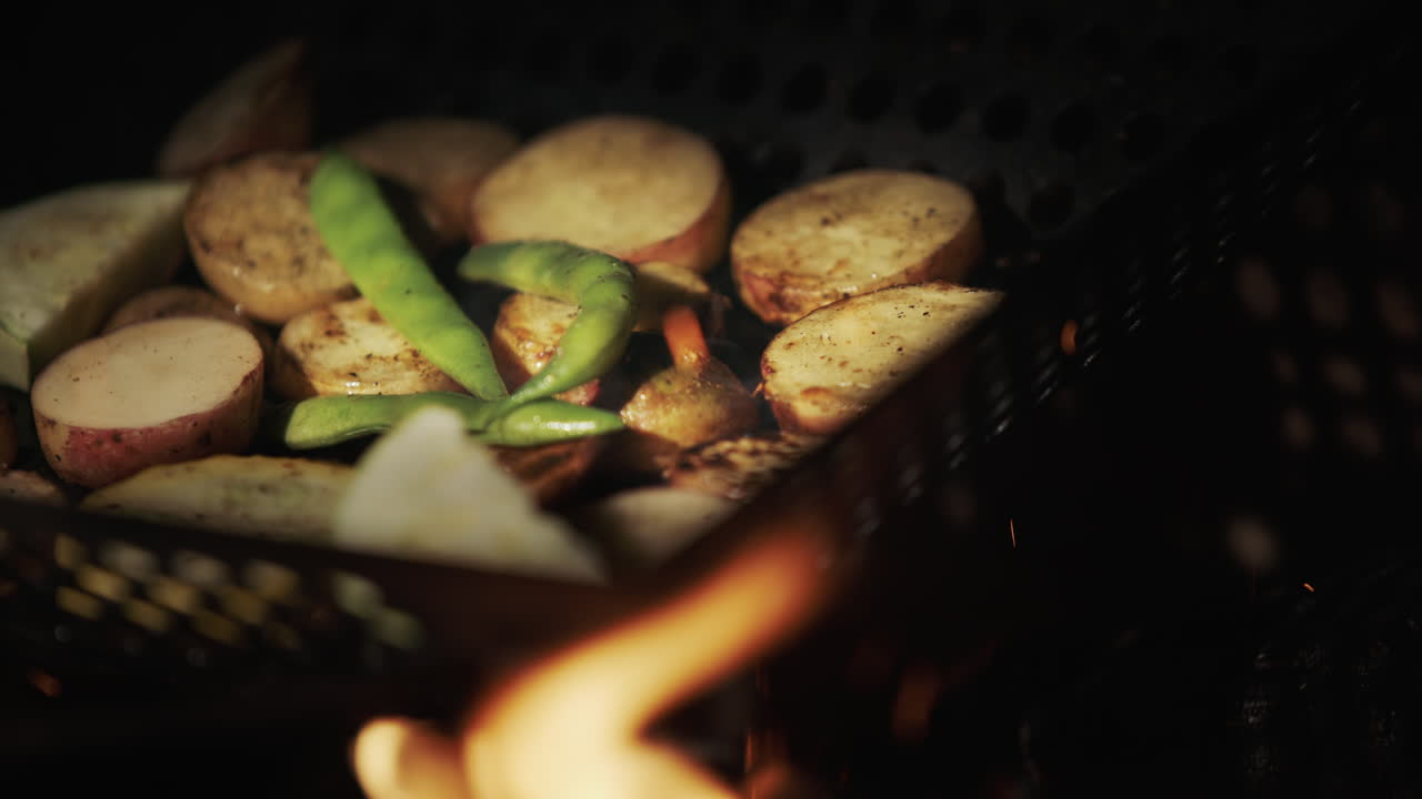 Potatoes with asparagus are fried in a frying pan over an open fire. Delicious picnic food
